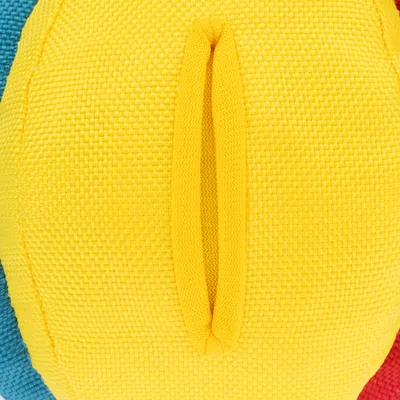 Gros plan sur une balle en tissu jaune avec coutures visibles, parties latérales bleu et rouge également visibles.