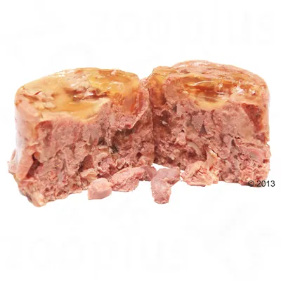 Dvije polovice mokre hrane za kućne ljubimce, vidljiva tekstura komadića mesa i želea, bez ambalaže ili oznaka brenda.