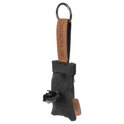 Distributeur de sacs en tissu noir avec lanière marron portant le texte BE NORDIC et étiquette TRIXIE, anneau métallique pour accrocher, sac plastique noir visible à l’ouverture.