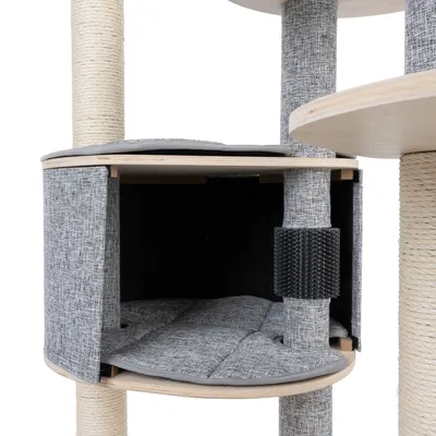 Niche d’arbre à chat en tissu gris avec coussin matelassé, poteaux recouverts de sisal et griffoir noir visible sur un des poteaux.