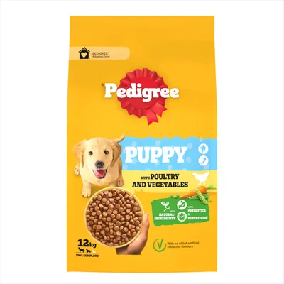 Bag labelled 'Puppy with poultry and vegetables', 12kg, showing kibble pieces, highlights natural ingredients, prebiotics, superfoods, no added artificial colours or flavours.