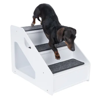 Hund steigt eine weisse Treppe mit drei Stufen hinunter, die mit grauem Teppich bezogen sind. Produkt zeigt Nutzung einer Haustiertreppe.