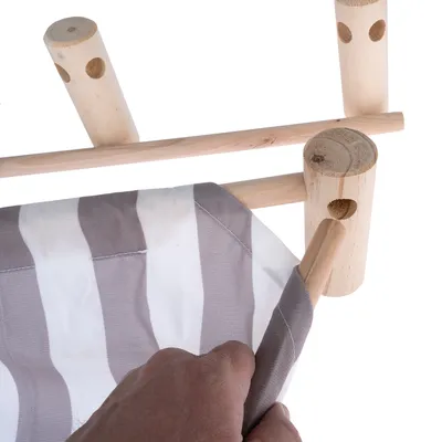 Montage van gestreepte stof op een houten frame met ronde verbindingsstukken. Hand trekt de stof over de houten staaf.