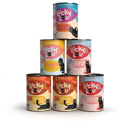 Lucky Lou cat food in cans: varieties duck, lamb, beef and poultry. Visible texts: 'Ente GUT, alles GUT', 'VerLAMM Gut!', 'Beef UP', 'Geflügel den Geist', 'Beef me UP'.