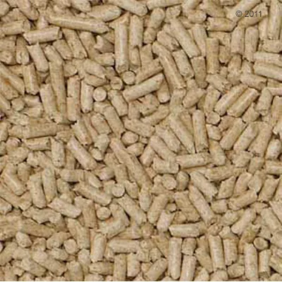 Närbild av ljusbruna pellets, möjligen djurströ eller foderkomponenter. Inga ytterligare uppgifter synliga.