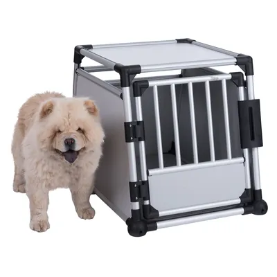 Metal transport box with grid door and plastic elements, next to a dog. Suitable for safe transport of pets.