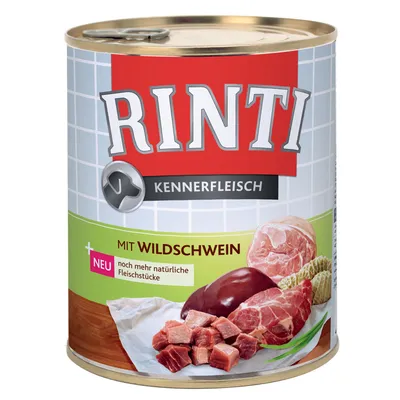Rinti Kennerfleisch hondenvoer blik, mit Wildschwein. Tekst: NEU noch mehr natürliche Fleischstücke. Afbeelding van vleesstukken op de verpakking.