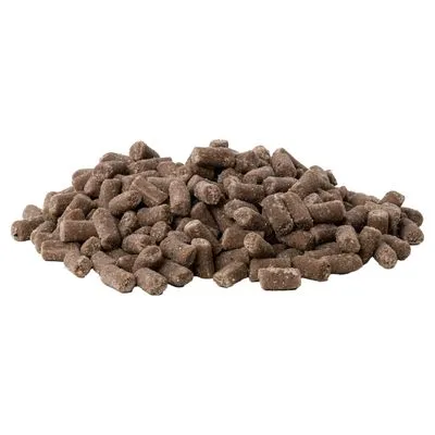 Bruine brokjes diervoeding in cilindervorm, los gestapeld op een witte achtergrond. Geen merknaam of verpakking zichtbaar.