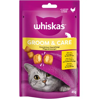 Whiskas Groom & Care mit Huhn, Pflege für Haut und Fell, mit Zink und Omega-6. Verpackung zeigt Katze unter Decke und Snackstücke. Gewicht: 45g.