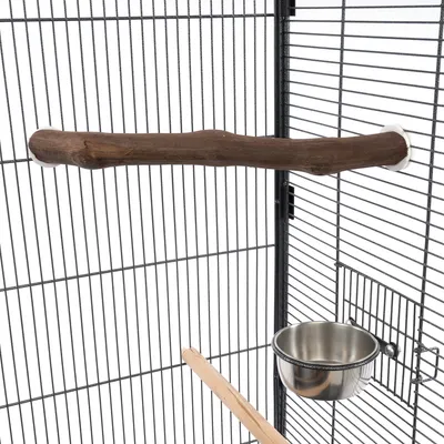 Vogelkäfig mit Holzsitzstange, Edelstahl-Futternapf und Gittertür. Zubehör für Vögel sichtbar montiert.