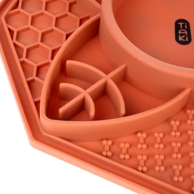 Tiaki krmná podložka z oranžového silikonu s různými texturami a prohlubněmi pro pomalé krmení.