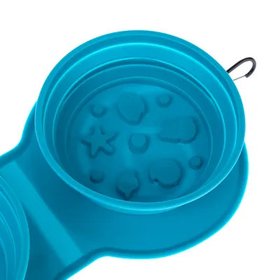 Gamelle pliante en silicone bleu avec motifs reliefs coquillages et étoile de mer, crochet métallique visible sur le bord.