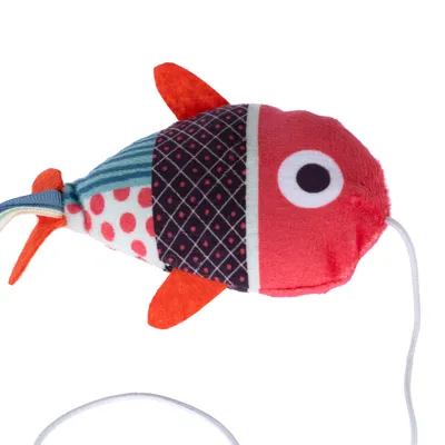 Pez de juguete de tela con patrones rojos, negros y blancos y una cuerda. Adecuado para juego interactivo.