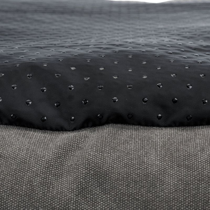 Nahaufnahme eines schwarzen, wasserabweisenden Materials mit Tropfenstruktur und grauem Stoff darunter.