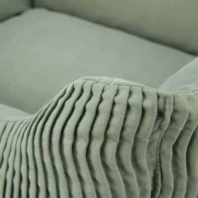 Nahaufnahme eines grünen Stoffbezugs mit geriffelter Struktur, geeignet für Möbel oder Accessoires.