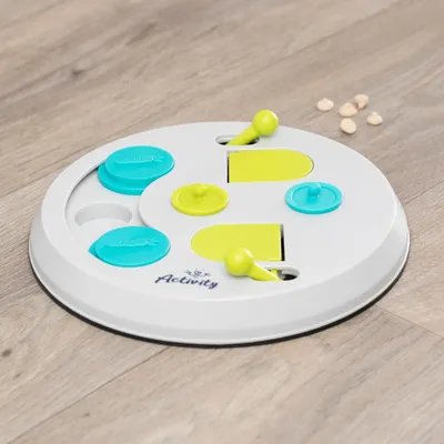 Rundes Intelligenzspielzeug mit gelben und blauen Elementen, Marke Activity. Geeignet für das Verstecken von Leckerlis auf einer Holzoberfläche.