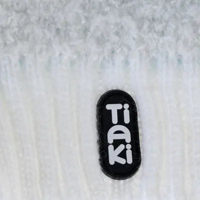 Tiaki. Markenlogo auf weissem, strukturiertem Hintergrund.