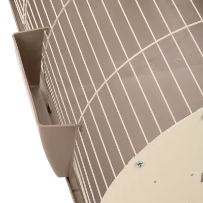 Détail d’une cage en métal blanc avec base et mangeoire en plastique beige, vue rapprochée sur les barreaux et la fixation de la structure.