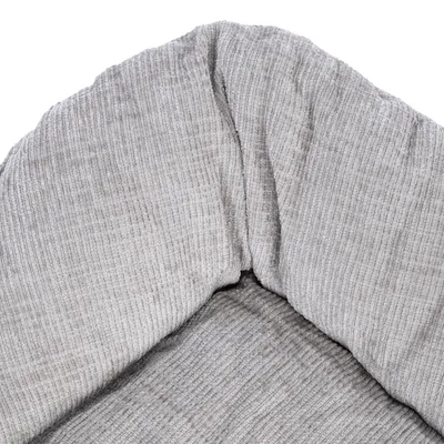 Gros plan sur le tissu côtelé gris d’un panier ou coussin pour animal, sans marque visible ni autres éléments distinctifs.