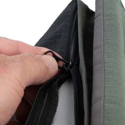 Primer plano de una cremallera que se abre para mostrar el material interior de un producto.