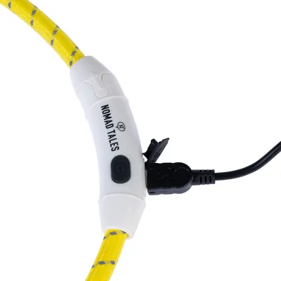 Nomad Tales gelbes Kabel mit weissem Anschlussstück, USB-Ladeanschluss und Ein-/Ausschalter sichtbar.