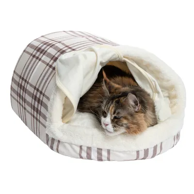 Chat allongé dans une niche en tissu à motif écossais beige et marron, intérieur doublé de fausse fourrure blanche.