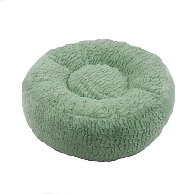 Rond, mintgroen knuffelbed met een zachte, gestructureerde oppervlakte.