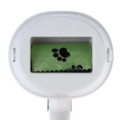 Dispensador blanco con rollo verde de bolsas para excrementos de perro, con huellas de patas negras impresas.