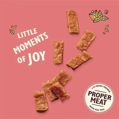 Text reads 'Little moments of joy' and 'Proper Meat with freshly prepared, never meat meal'. Image shows several rectangular meat treats on a pink background.