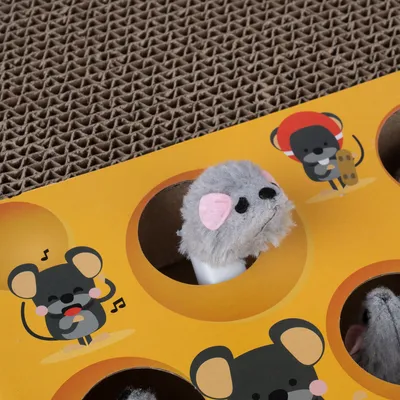 Legetøj med grå plysmus, der kigger ud af et hul i en gul papoverflade med museillustrationer.
