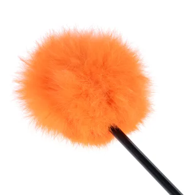 Juguete con bola de felpa naranja y varilla negra, adecuado para juego interactivo.
