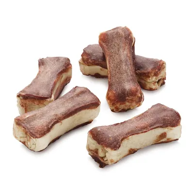 Cinq friandises en forme d’os, aspect bicolore brun et beige, sans emballage visible, posées sur fond blanc. Cinq friandises en forme d’os, aspect bicolore brun et beige, sans emballage visible, posées sur fond blanc.