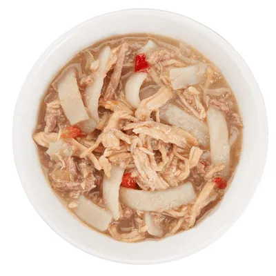 Morceaux de viande effilochée et légumes en sauce dans une gamelle blanche, aliment humide pour animaux. Aucun emballage ou marque visible.