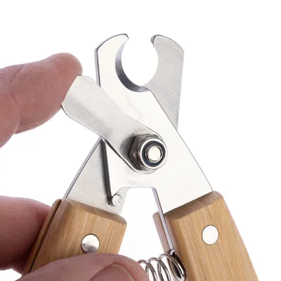Nagelzange aus Metall mit Holzgriff, Detailaufnahme der Schneidefläche und Federmechanismus.