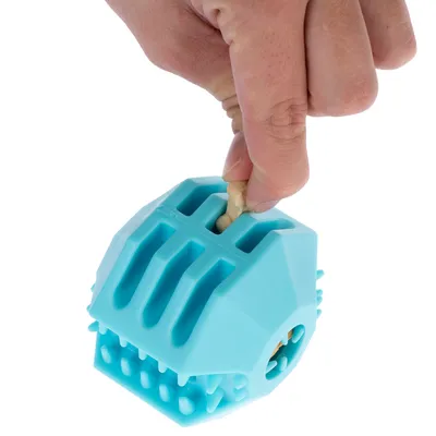 Una mano mostra come inserire uno snack in un gioco blu con aperture e protuberanze.