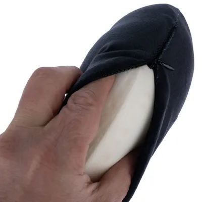 Kéz kinyitja a fekete huzatot cipzárral, hogy megmutassa a belső fehér szivacsot.