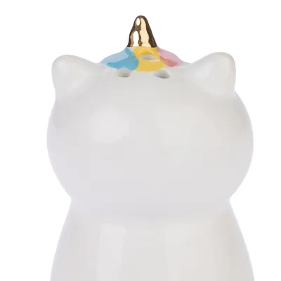 Figurine en céramique blanche en forme de chat avec corne dorée et détails colorés bleu, jaune et rose sur la tête. Trois petits trous visibles sur le dessus.