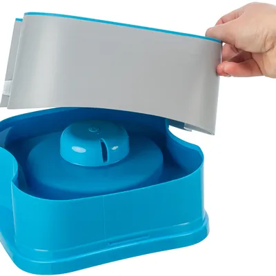 Una mano solleva il coperchio di una fontanella blu per mostrare l'interno.