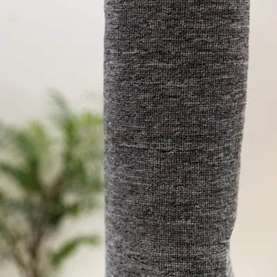 Gros plan sur un poteau recouvert de tissu gris, texture tissée visible. Aucun logo ni texte apparent.