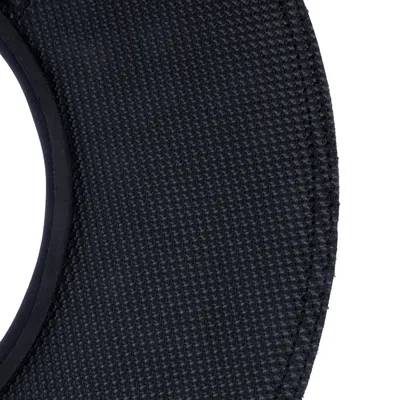 Nahaufnahme eines schwarzen, strukturierten Gewebematerials mit sichtbarer Naht.