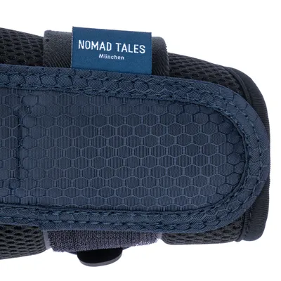 Étiquette visible sur harnais en tissu bleu avec inscription : NOMAD TALES München