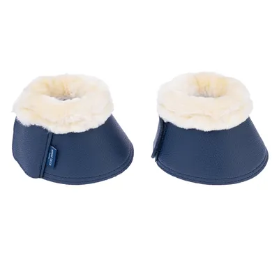 Paire de protège-sabots bleu foncé avec intérieur en fausse fourrure crème, étiquette visible marquée 'TRIXIE', matière extérieure aspect cuir.