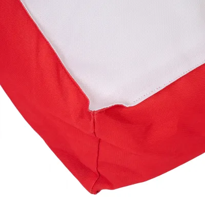Gros plan sur un coin de coussin ou panier pour animal en tissu rouge et blanc, coutures visibles. Matière textile uniquement, aucun logo ni texte apparent.