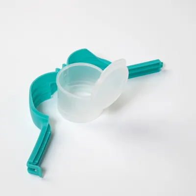 Turkizna plastična sponka s prozornim merilnim lončkom in pokrovom, primerna za odmerjanje živalske hrane.
