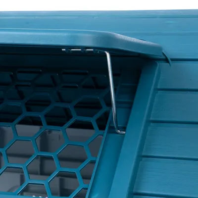 Detailní pohled na modrou přepravku s šestihrannou mřížkou a kovovým uzávěrem.