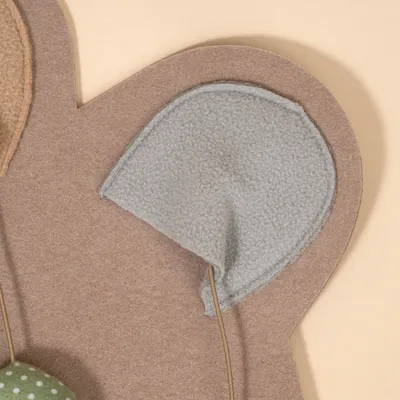 Detailaufnahme eines grauen Filzmaterials mit Drahtverstärkung, Teil eines Spielzeugs oder Zubehörs.