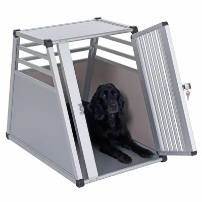 Transportbur i metall med öppningsbar dörrdesign, svart hund ligger inuti. Buren har ventilationsspringor och låsbar dörr.