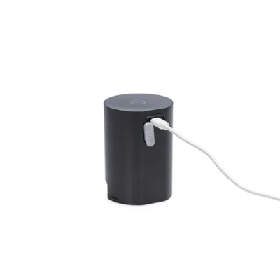 Appareil cylindrique noir avec câble blanc branché sur un port USB, étiquette visible portant l’inscription 'PETKIT'.