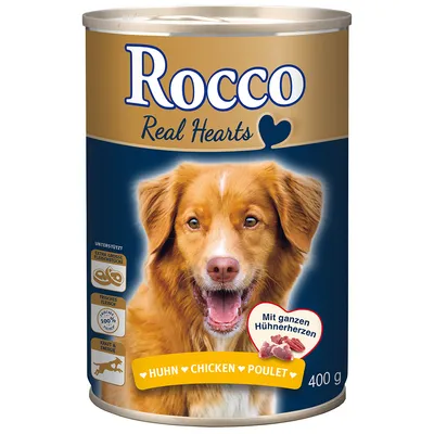 Blik Rocco Real Hearts hondenvoer, smaak kip, 400 g. Tekst: Huhn, Chicken, Poulet. Afbeelding van hond en stukjes vlees op het etiket.