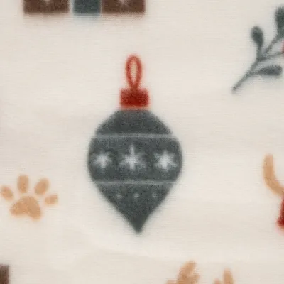 Primo piano di un motivo tessile con una pallina di Natale grigia, impronta di zampa e ramo su sfondo color crema. Primo piano di un motivo tessile con una pallina di Natale grigia, impronta di zampa e ramo su sfondo color crema.